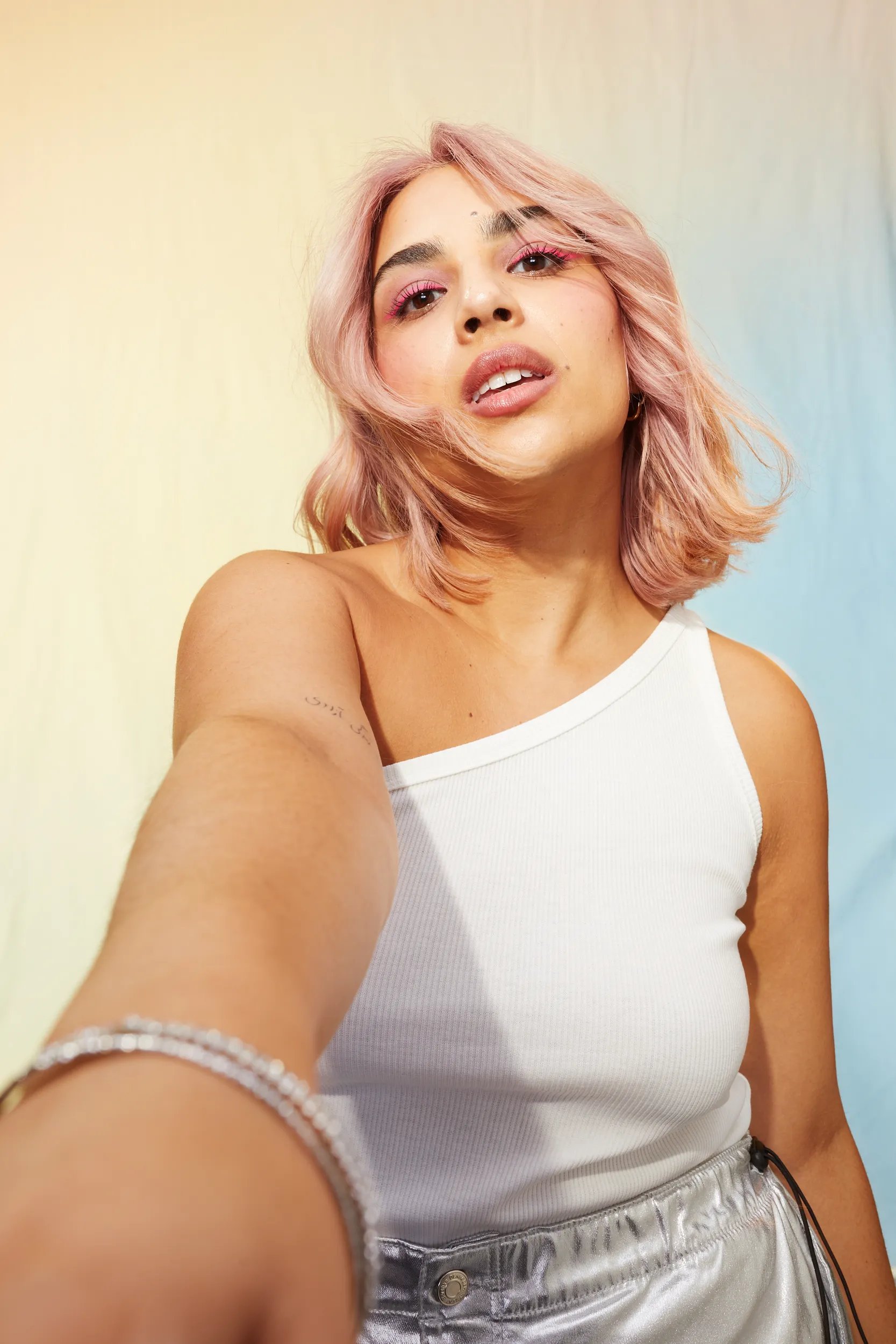 Sheen Fatemi photoshoot with pink medium length hair and white outfit